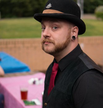 Person at BiCon Bisexuality Convention wearing suit and bowler hat