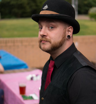 Person at BiCon Bisexuality Convention wearing suit and bowler hat